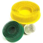 Three circular massage pin cushions (silicone bristle brushes) in yellow, green, and white.
